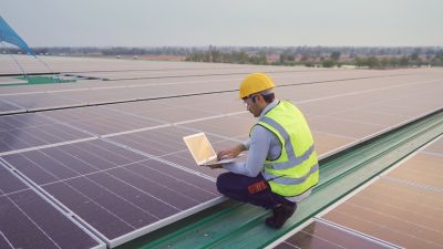 Solar panel technician inspecting panels